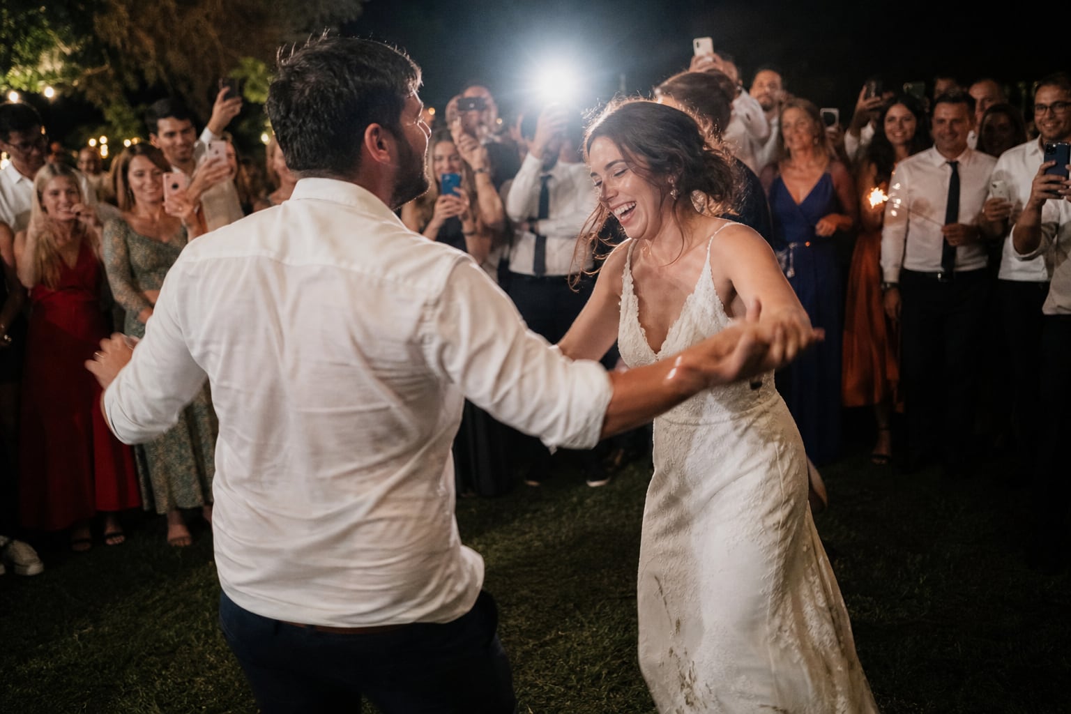 First dance at night, guests filming on their phones, at a wedding in Spain